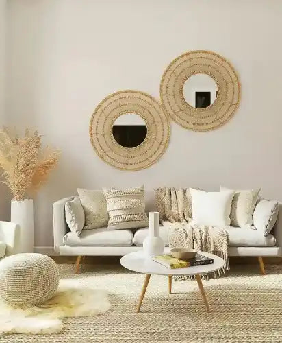 Living room with a white sofa, round mirrors, and decorative items.